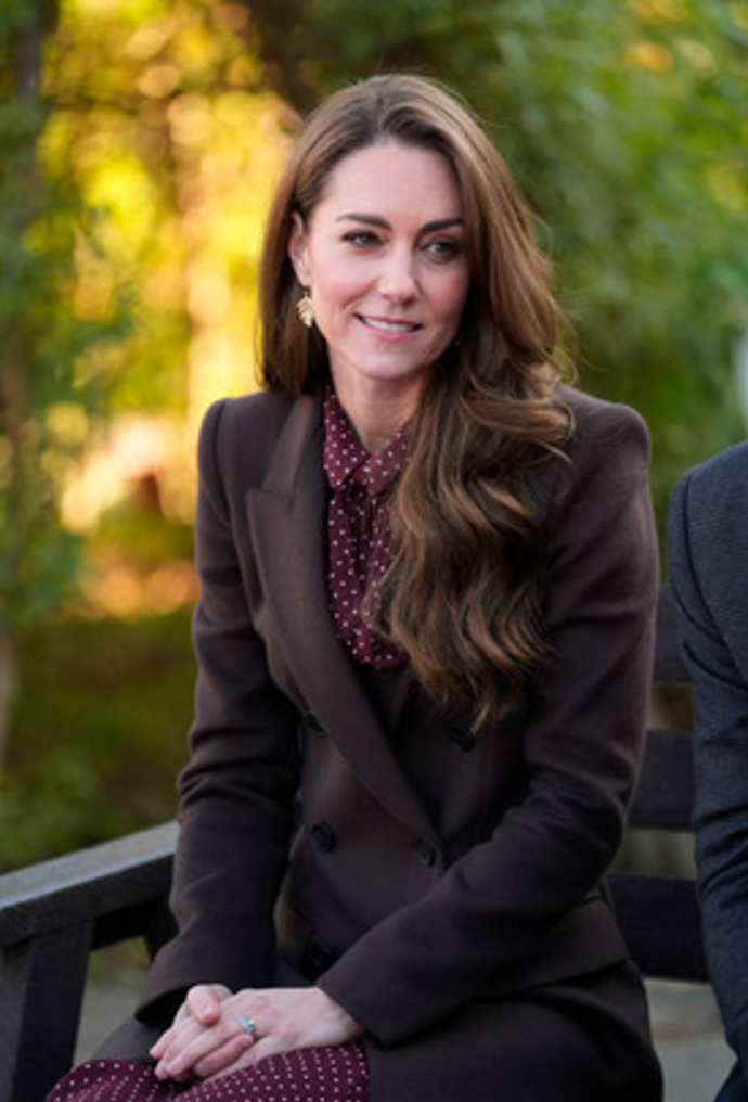 Hnědý kabát v kombinaci s vínovou halenkou s puntíky působí na Kate Middleton hravě i elegantně zároveň. Tmavší odstín kabátu celý look zklidňuje, zatímco výrazná halenka dodává outfitu osobitý šmrnc. Puntíkový vzor odlehčuje formálnější charakter kabátu a přináší do podzimního stylu svěžest. Celek je důkazem, že i drobné detaily dokážou změnit náladu celého outfitu.
