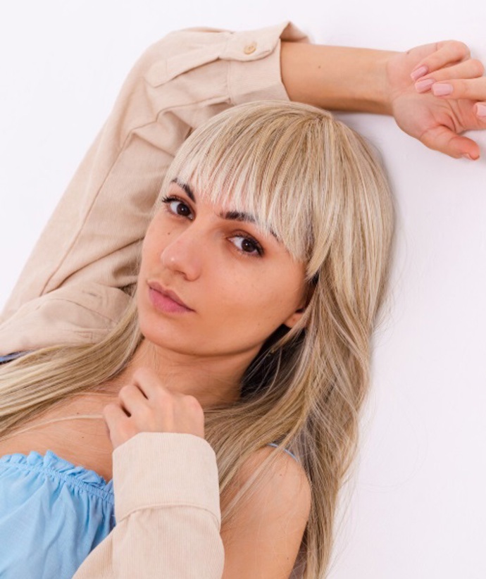 Rovná ofina spadající do obočí patří mezi moderní střihy, které nosí ženy po celém světě. S blond vlasy navíc krásně vynikne. 
