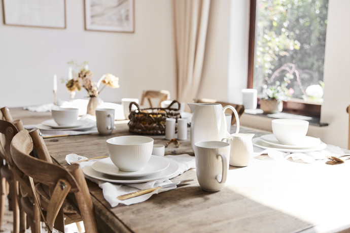 Stůl prostřený bílým porcelánem a lněnými ubrousky připomíná, že venkovský styl je o hostinnosti a rodinných setkáních.
Stůl prostřený bílým porcelánem a lněnými ubrousky připomíná, že venkovský styl je o hostinnosti a rodinných setkáních.