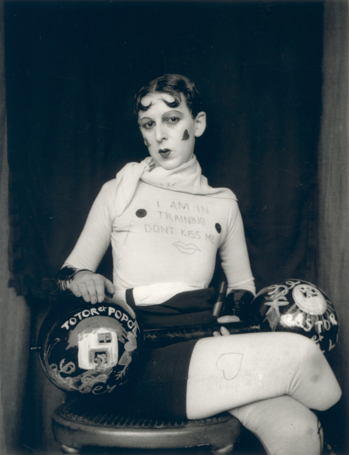 Jeden z mnoha autoportrétů Claude Cahun. Má na sobě tričko s nápisem „Jsem v tréninku, nelíbejte mě.“
Jeden z mnoha autoportrétů Claude Cahun. Má na sobě tričko s nápisem „Jsem v tréninku, nelíbejte mě.“
