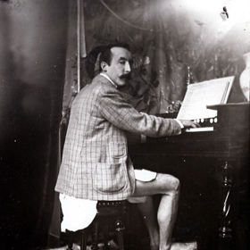 Paul Gauguin na snímku pořízeném kolem roku 1895 hraje na harmoniku v ateliéru Alfonse Muchy v Paříži. Zajímavostí je, že právě Alfons Mucha, český malíř a grafik z období secese, je autorem fotografie.
