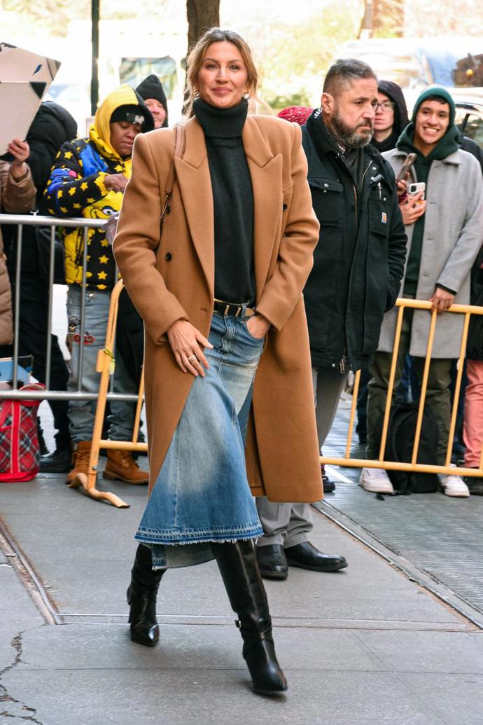 Supermodelka Gisele Bündchen si vyrazila v denimové sukni, kterou doplnila vlněným kabátem ve velbloudím odstínu, hřejivým černým rolákem a populárními slouchy kozačkami. 
