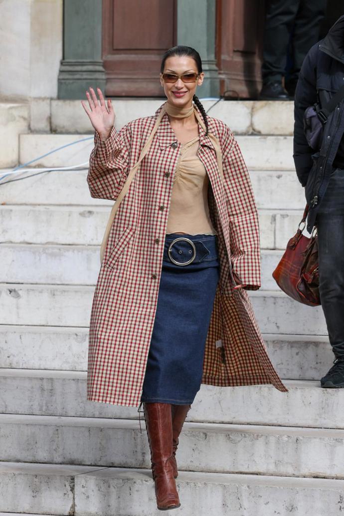 Americká supermodelka Bella Hadid sáhla podobně jako její kolegyně po džínové midi sukni s výraznou sponou. Tu však doplnila károvaným kabátem a hnědými kozačkami. 
