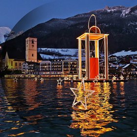 Adventní trhy a atmosféra na jezeře Wolfgangsee v rakouské Solné komoře

Jen pár hodin cesty autem vás dělí od malých vesniček Strobl, St. Gilgen a St. Wolfgang, která leží u jezera Wolfgansee v Rakousku. Tady vás nečekají jen tradiční adventní trhy. Vládne tady té pravé pohádkové vánoční atmosféry. Každá z vesniček má svůj motiv: Strobl šestimetrovou vánoční hvězdu, St. Wolfgang má na hladině jezera obří šestnáctimetrovou vánoční laternu a St. Gilgen na severním okraji jezera zdobí devět metrů vysoká adventní svíce. Domy všech  jsou kouzelně vyzdobeny, v každé uličce je na co se dívat. A všechno se dá stihnout za jediný den, parníky jezdí v pravidelných půlhodinových intervalech od osmé hodiny ranní až do osmi večer. Přitom tu panuje zvláštní, sváteční ticho a rozjímavý adventní klid. 

Atmosféru kouzelného městečka St. Wolfgang dodnes neodmyslitelně dotváří hotel na břehu jezera Im Weissen Rössl (U bílého koníčka). Nabízí luxusní ubytování v tradičním rakouském stylu, dvě restaurace s výhledem na jezero, v nichž vaří z lokálních surovin šéfkuchař oceněný rakouskými michellinskými hvězdami Hermann Poll. Ochutnáte tady skvělá vína a rozmazlovat se můžete nechat v hotelovém spa, v němž je možnost koupání ve vyhřívaném jezerním koupališti.

 
