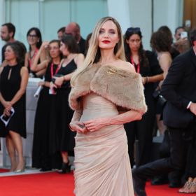 Kráska Angelina Jolie oblékla nádherné společenské šaty pleťové barvy, které doplnila kožešinovým límcem a výrazným líčením. 
