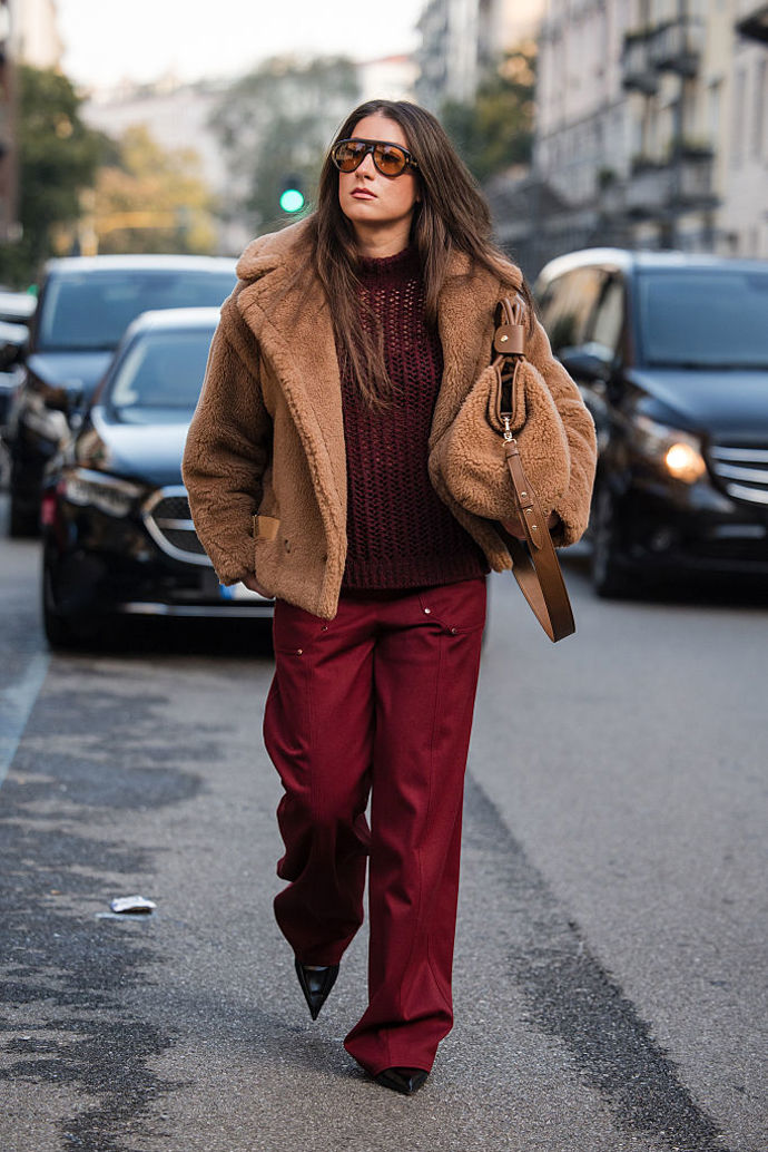Hnědý teddy kožíšek spojte s kabelkou ze stejného materiálu a přidejte outfit v trendy vínovém odstínu.
