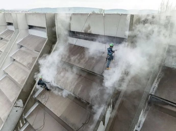Betonová střecha objektu byla časem pokryta řasami, lišejníky a mechy. U starších průmyslových staveb to není neobvyklé. Biologické nánosy zde byly desítky let a vizuálně měnili vzhled budovy. Proto byl zvolen postup, který klade důraz na teplotu páry a minimální tlak, nikoli na mechanické či chemické zásahy.
Betonová střecha objektu byla časem pokryta řasami, lišejníky a mechy. U starších průmyslových staveb to není neobvyklé. Biologické nánosy zde byly desítky let a vizuálně měnili vzhled budovy. Proto byl zvolen postup, který klade důraz na teplotu páry a minimální tlak, nikoli na mechanické či chemické zásahy.