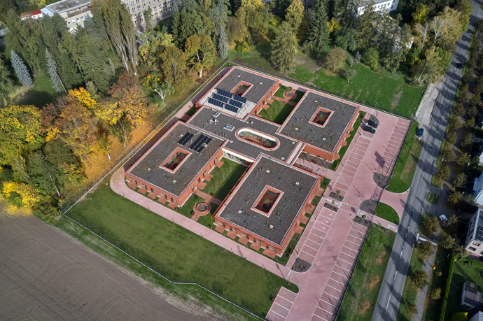 Cihlový dům obklopený zelení pracuje s tichem, světlem a důstojností. Místo ústavu nabízí skutečný domov.
