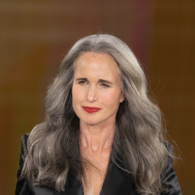 Černá barva není úplně zakázána, ale inspirujte se Andie MacDowell (67): výstřih do V, saténová lesklá látka a výrazná rtěnka

