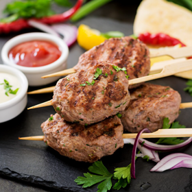 Kofta
Kofta pochází z oblasti Blízkého východu, Turecka a Balkánu. Připravuje se z mletého hovězího nebo jehněčího masa ochuceného česnekem, cibulí, kmínem či koriandrem. Masové válečky nebo kuličky se grilují nebo pečou a podávají se s chlebem pita, rýží a jogurtovým dipem.
