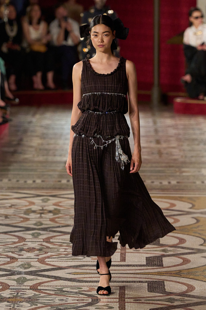 Plisované šaty nechybí ani v aktuální haute couture kolekci módního domu Chanel.
