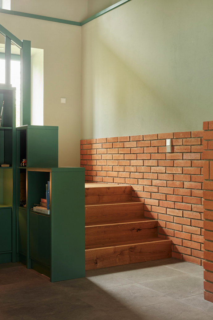 Schodiště je plnohodnotnou součástí obytného prostoru a dominuje mu sedací okno, kde mohou majitelé pohodlně vyhlížet do zahrady a v klidu odpočívat. 
