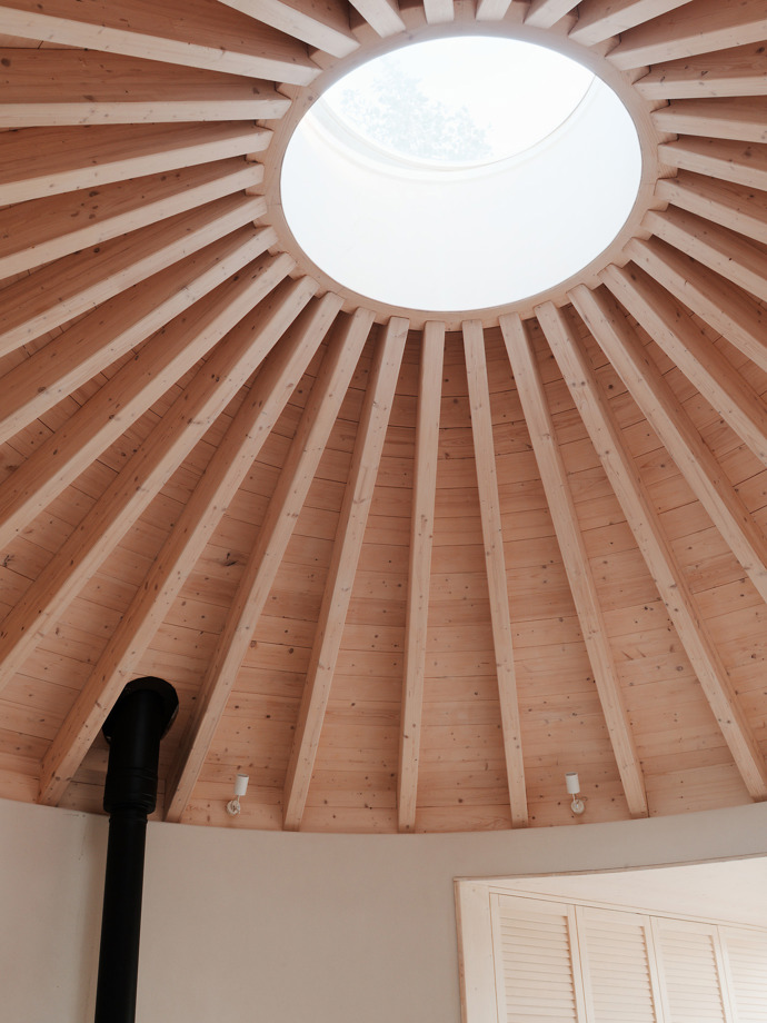 Tvar tradiční kruhové jurty uchvátil mladý manželský pár, který si chtěl postavit víkendový domek. Architekti jim přání splnili a vytvořili jednoduchou dřevostavbu, která zadání dokonale splňuje. 
