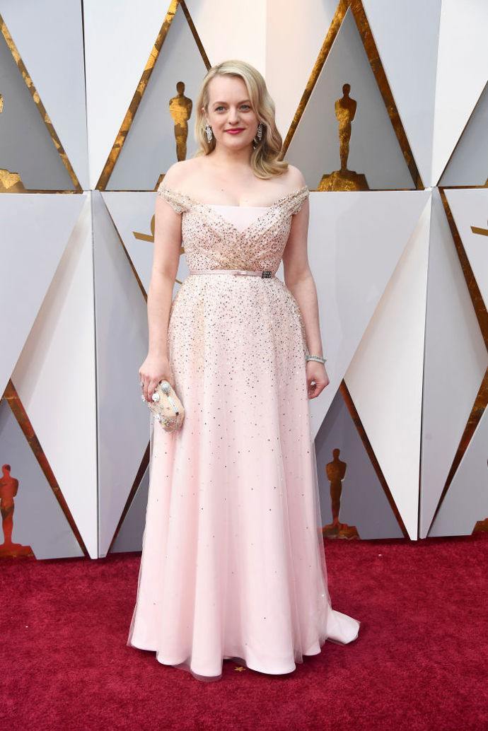 Elizabeth Moss v šatech od Christiana Diora s kabelkou od Rogera Viviera a botách Brian Atwood.
