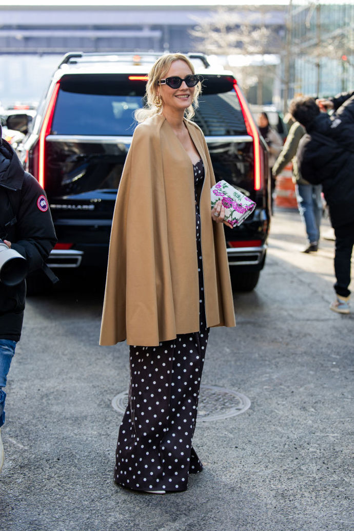 K černému overalu s bílými puntíky herečka a modelka Diane Kruger oblékla béžovou pelerínu a kontrastní květovanou kabelku.
