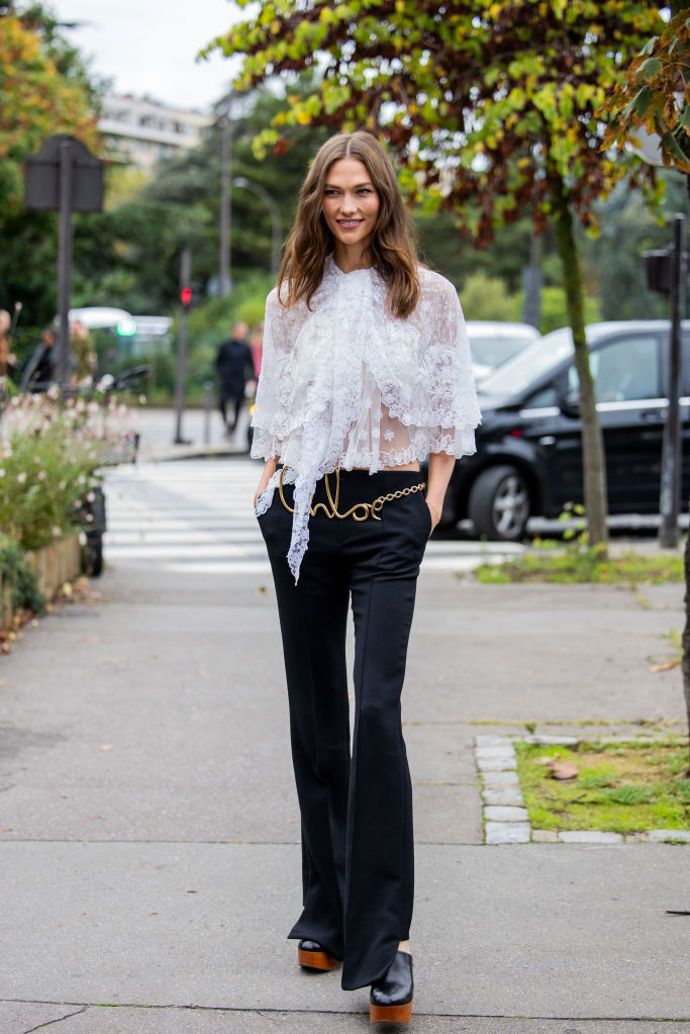 Modelka Karlie Kloss obula k černým kalhotám do zvonu clogs v černohnědém provedení.

