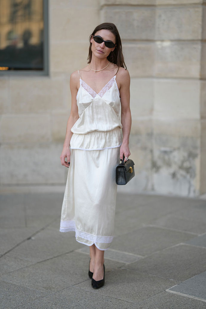 Minimalistický a zároveň romantický letní outfit mohou být i krémové slip šaty s bílou krajkou
