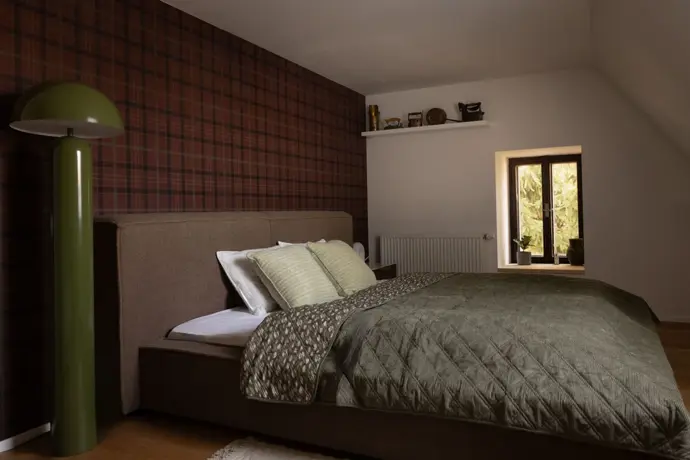 Vysoká zelená designová lampa dala této ložnici jméno.
