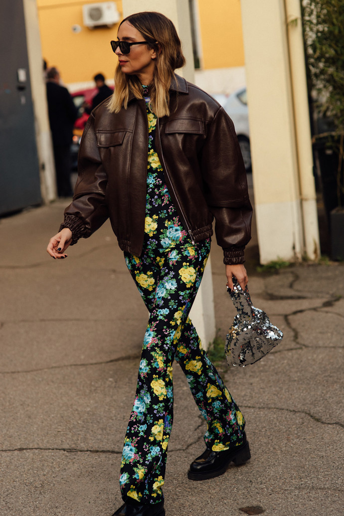 Květinový overal a k němu stříbrná flitrovaná kabelka? Styling na fashion week někdy zkrátka musí být trochu „over the top“.
