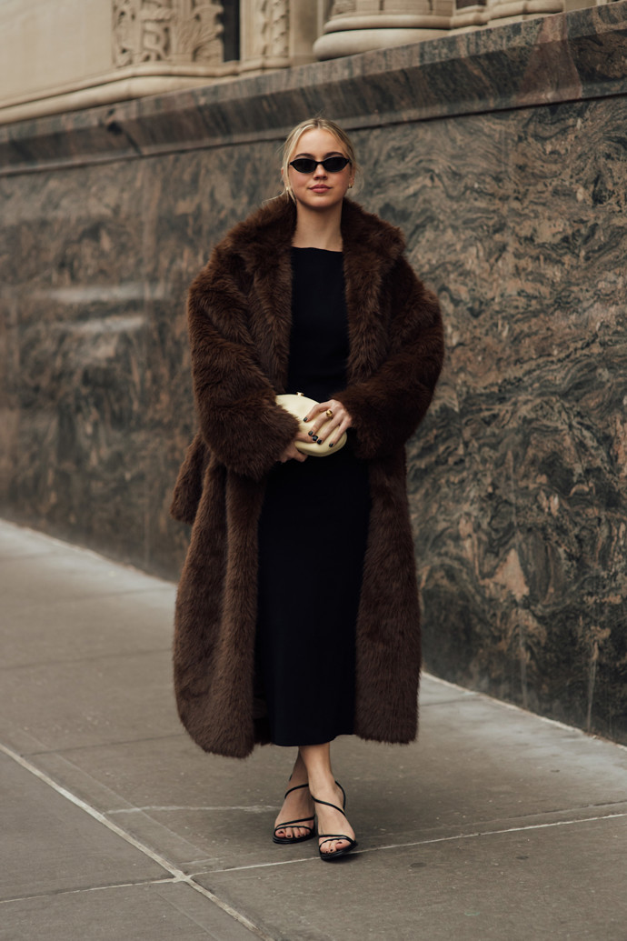 Na fashion weeku v New Yorku samozřejmě nemohl chybět outfit ve stylu Carrie Bradshaw – tmavě hnědý kožich s páskovými sandálky.
