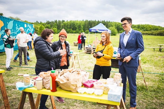 Velkou roli hraje také samotné prostředí. Kombinace lesa, otevřeného prostoru a komunitního zázemí působí spíš jako výlet mimo Prahu než městský projekt pár minut od rušných ulic.
