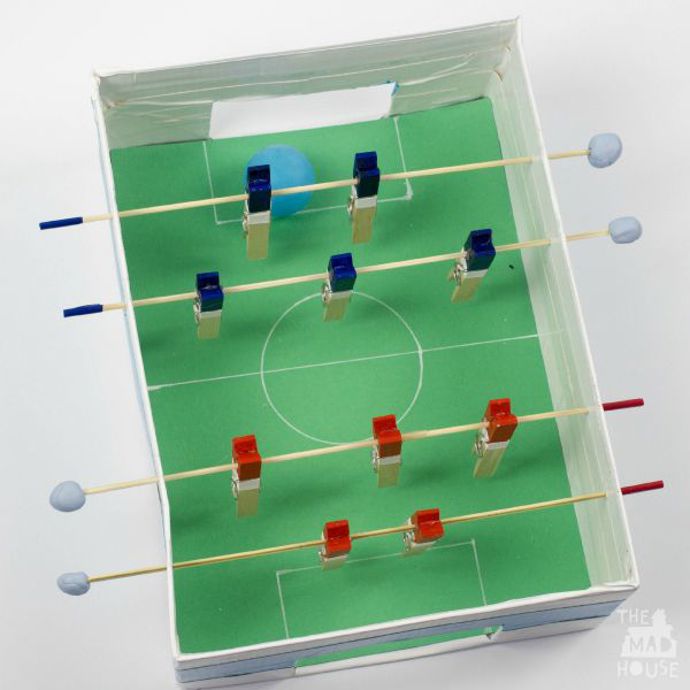 Stolní fotbálek z krabice od bot a kolíčků je tak jednoduchý, až je to geniální. Celý fotonávod najdete na blogu s optimistickým názvem Muminthemadhouse.com (máma v blázinci).
