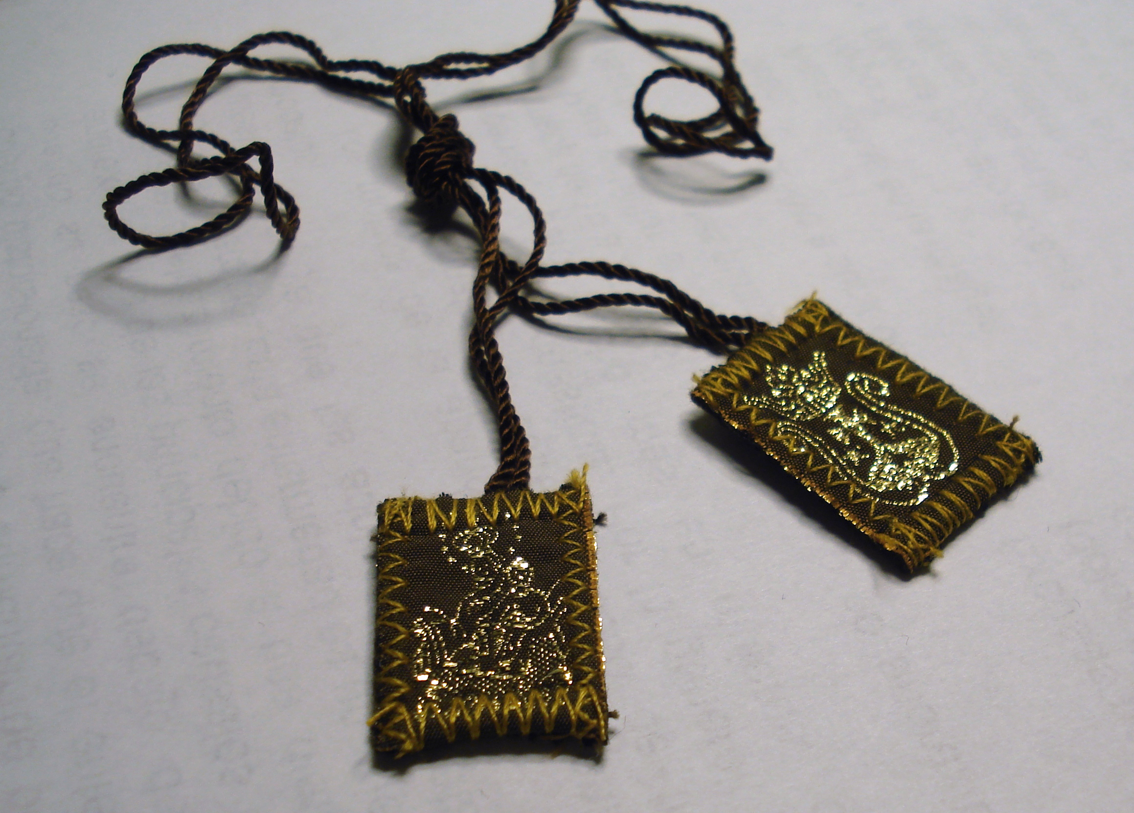 Devocionální škapulíř fungoval jako amulet nebo ikona pro věřící.
Devocionální škapulíř fungoval jako amulet nebo ikona pro věřící.