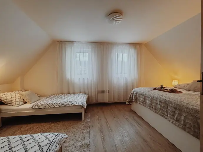 Ve větší ložnici je manželská postel a dvě jednolůžka.
