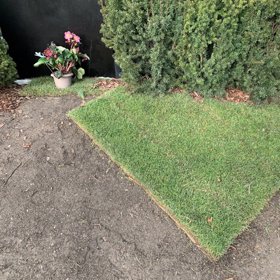 Za náhrodním kamenem přibyl nový umělý trávník.