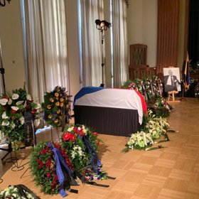 Rakev je zahalena českou vlajkou.