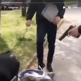 Poté klečícího mladíka kopli do zad.