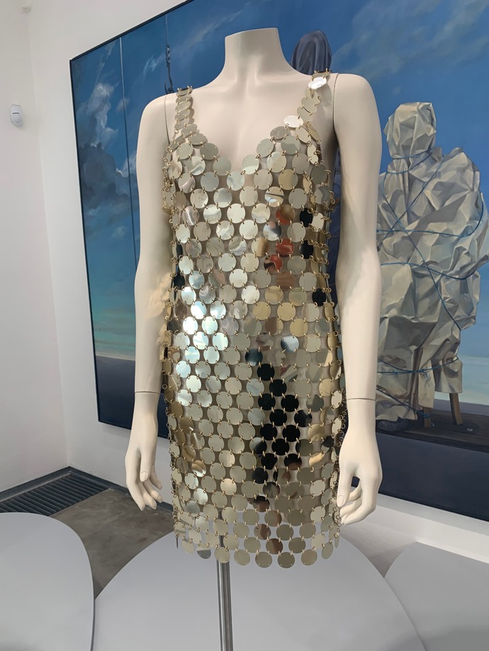 Stavebnicové šaty Paco Rabanne poprvé navrhl už v roce 1966. Pozadí mu tvoří maxi plátno od Theodora Pištěka Rodinný portrét z roku 1976.