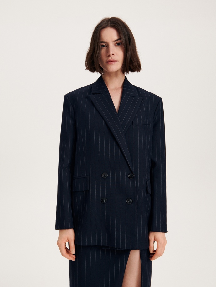 Proužkovaný nadměrný blazer a sukni z totožného materiálu nabízí značka Reserved.