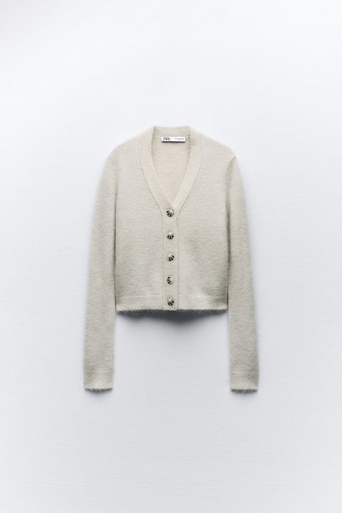 Perfektně je doladí propínací svetřík mohérového vzhledu s přiznanou zvířecí srstí lamy alpaky. (Zara, 999 Kč)