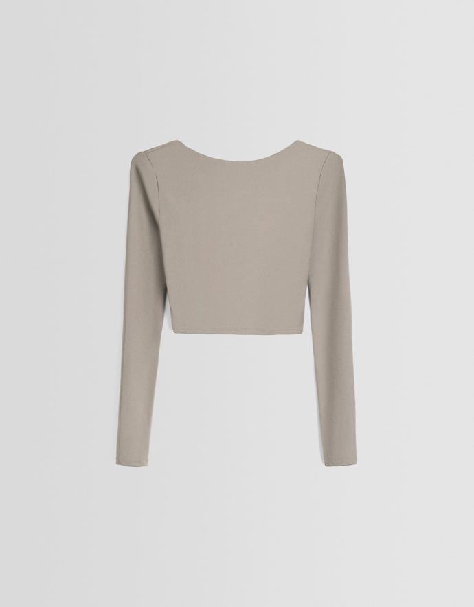 Propínací šaty bez rukávů jsou ideální k vrstvení ve stylu devadesátek, třeba s  jednoduchým tričkem s dlouhým rukávem. (Bershka, 399 Kč)