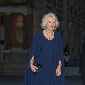 Camilla zvolila jednoduché šaty s impozantní pelerínou. Minimalistický střih bez přílišné zdobnosti dovolil Camille doplnit je úžasnou sadou rodinných klenotů.