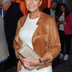 Helena Vondráčková si oblíbila kombinaci jednoduchých bílých šatů a hnědé kožené bundy, která se k šatům hodí - v černé barvě by šlo o příliš tvrdý konstrast.