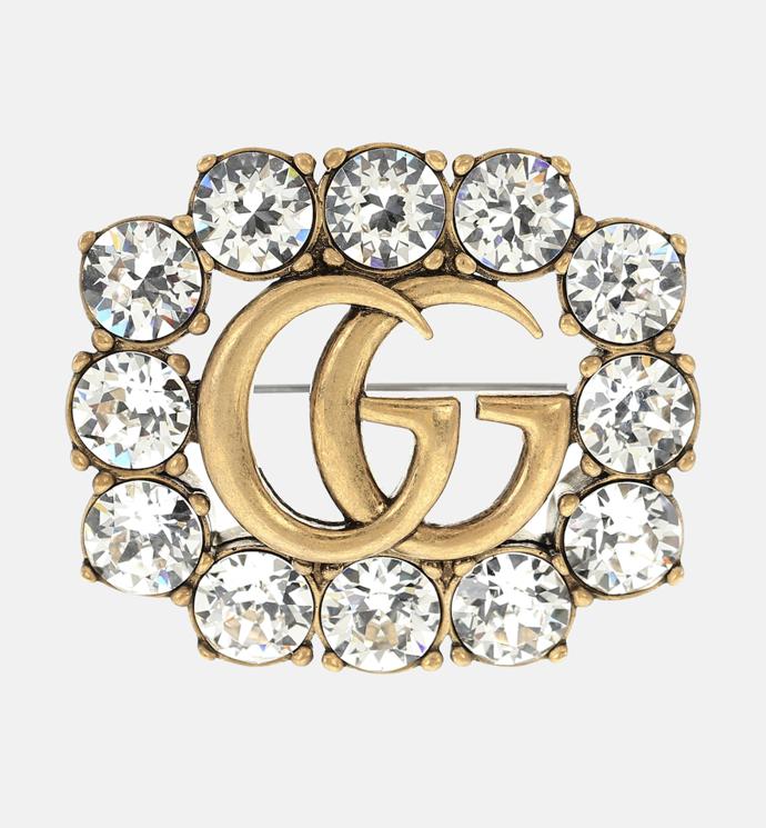 Štras na obrubě loga značky Gucci v podobě brože stejnojmenné značky. (8 790 Kč)