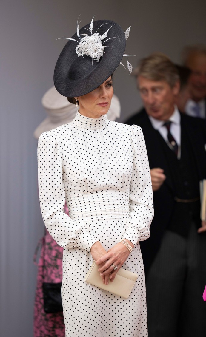 Dalším oblíbeným detailem je stojáček, který Kate Middleton zdobí na tomto snímku. 