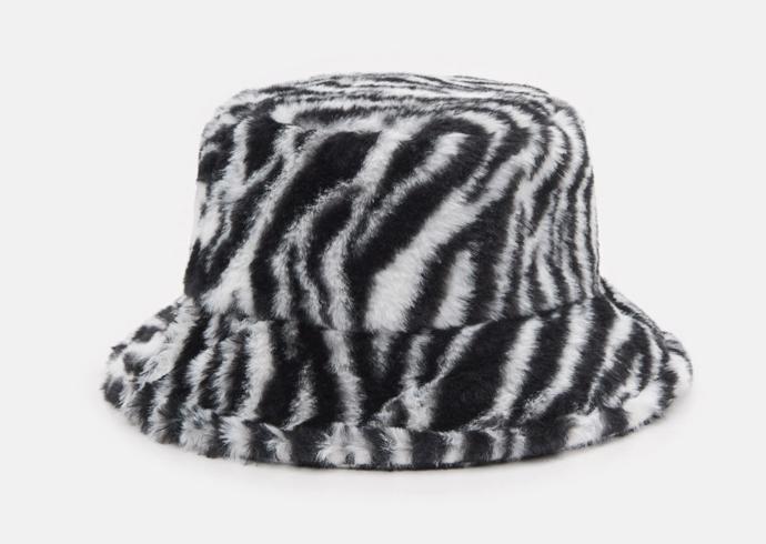 Extravgance je vítána. Zkuste třeba kožešinový "bucket hat" se zebřími vzory. Sinsay, 159 Kč