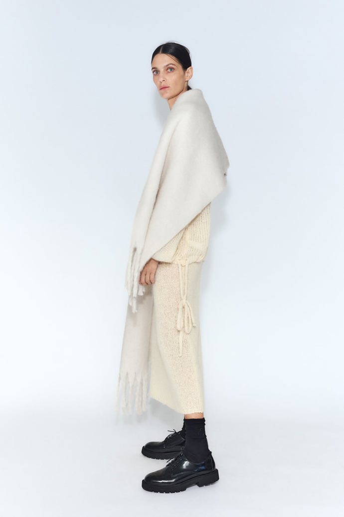 Maxi šálu si zamilujete, obzvlášť když bude hebká a v decentních neutrálních barvách. (Zara, 599 Kč)