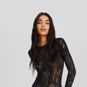 Top z průhledného materiálu obsypaný třpytivými prvky patří k nejuniverzálnějším průsvitným kouskům. (Body, Bershka, 559 Kč)