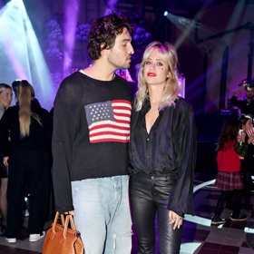 Jordan Haj oblékl světlé široké džíny, černý svetr s americkou vlajkou a coby doplněk mu posloužila hnědá unisex kabelka.