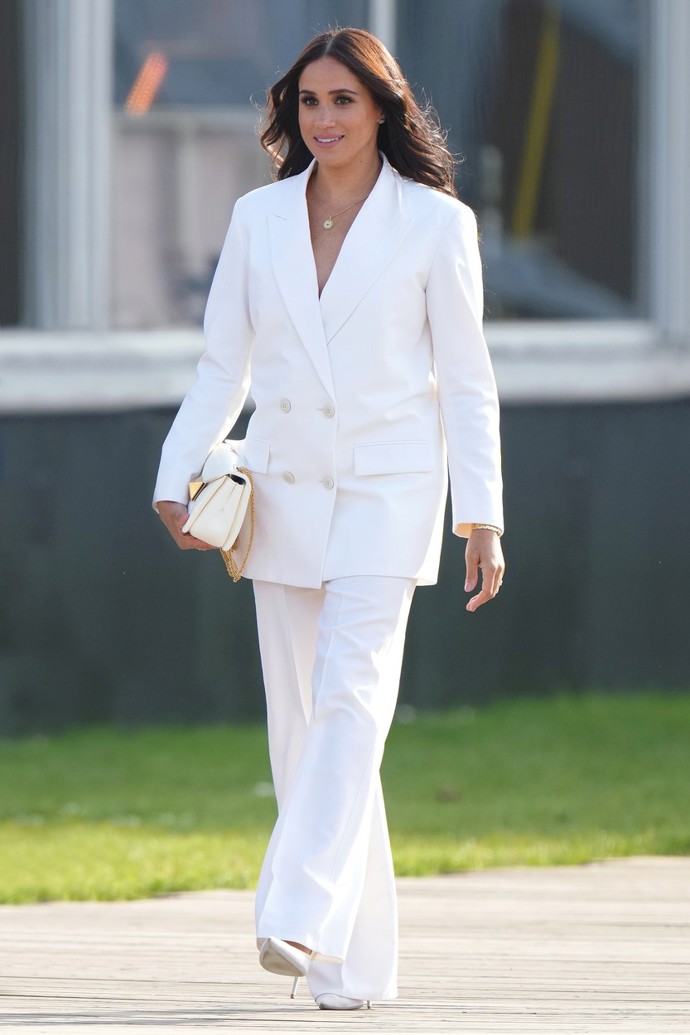 Bílá sedne i manželce prince Harryho Meghan Markle. V oversize kostýmku od Valentina dorazila na Invictus Games roku 2022 v Haagu.