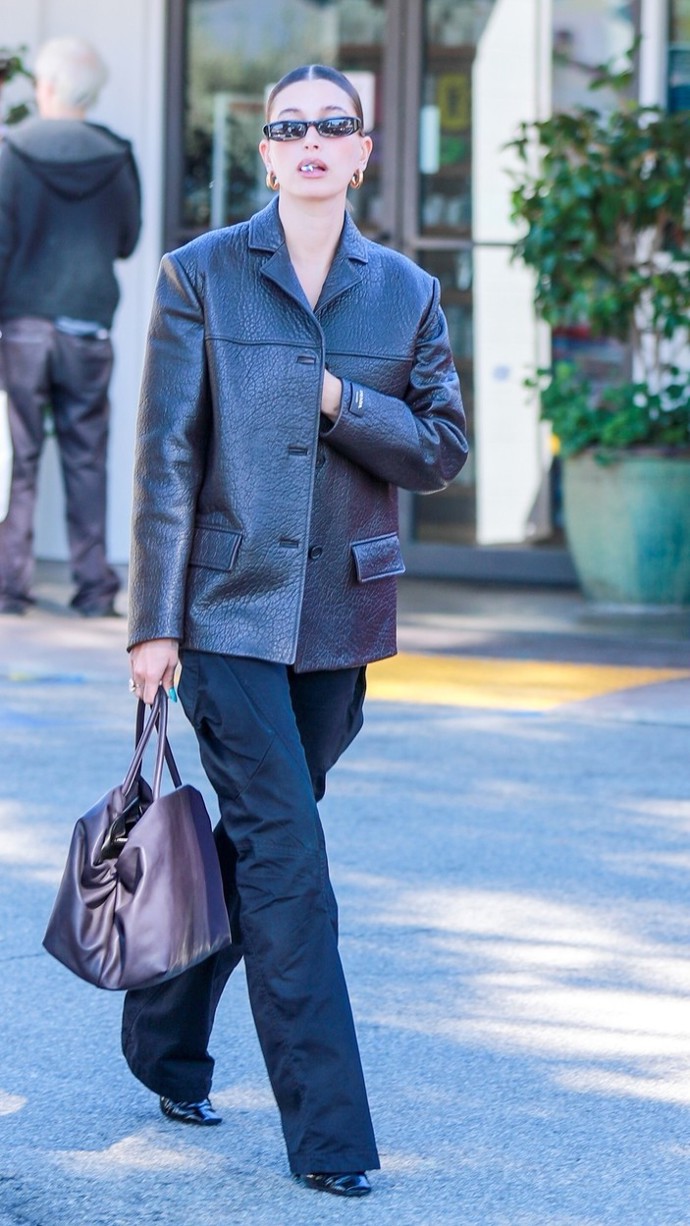 Hailey Bieber tíhne ke koženým kouskům. Dokazuje to i kombinací supertrendy cargo kalhot a košilové bundy Prada z luxusní kůže nappa. Téměř žádnému ze současných looků Hailey Bieber nesmí chybět sluneční brýle Saint Laurent model 557.