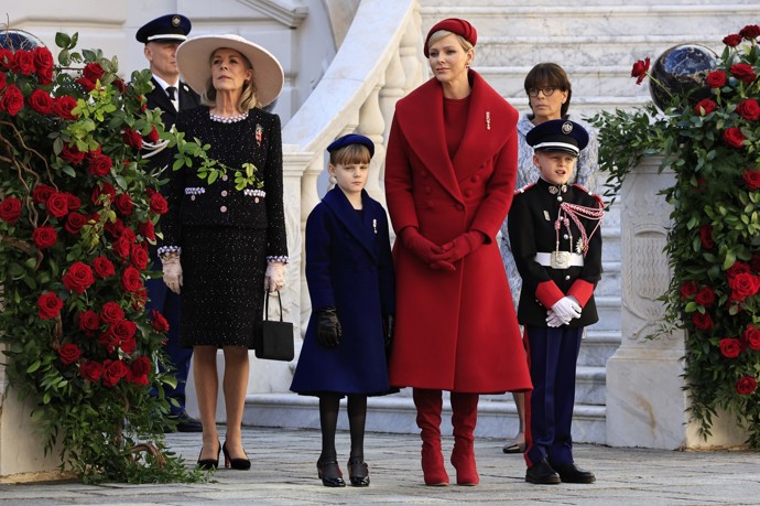 Stejný pařížský módní dům připravil také tento kněžnin karmínový outfit u stejné příležitosti. V kompletu s ním skvěle vynikly červené kozačky na jehlovém podpatku.