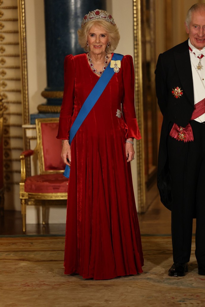 Na večerní banket se vyfikla také královna choť Camilla. Zvolila pro něj dlouhé sametové šaty značky Fiona Clare. Bez setu tiáry a náhrdelníku zdobených rubíny by ale efekt jejího outfitu byl poloviční.
