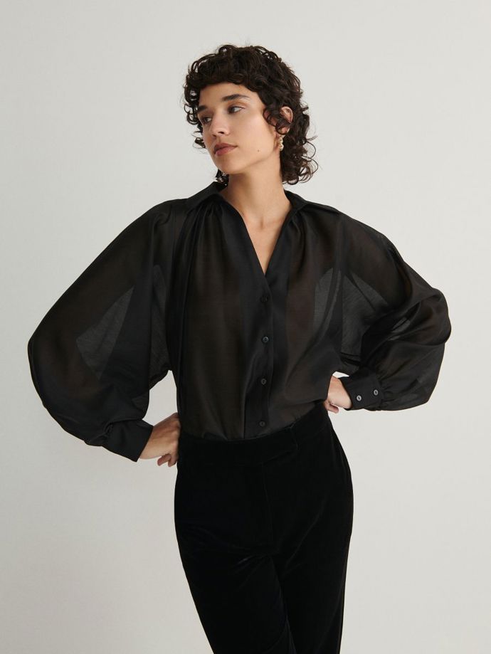Průsvitná košile s impozantním tvarem rukávů sedne k jednoduchým spodním dílům. (Reserved, 599 Kč)