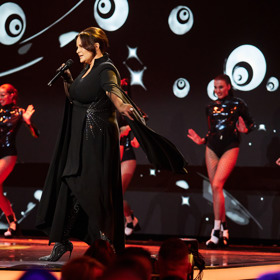 Stejně okouzlena je střihem i Jitka Čvančarová. Model, ve kterém vzdala hold Yvonne Přenosilové na letošních Slavících to jen potvrzuje a navíc herečce a zpěvačce neskutečně sedl. Doplnila jej opulentními a extravagantními kozačkami obsypanými třpytivými aplikacemi a také nepřehlédnutelnými průhlednými rukavičkami.