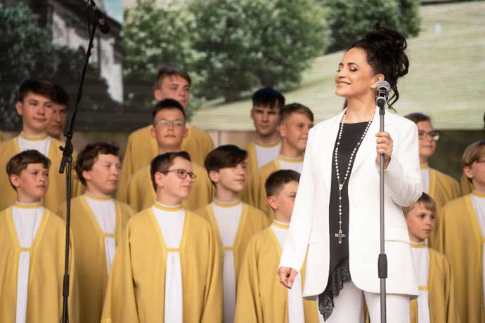 Součástí června Lucie Bílé byly koncerty s pěveckým sborem Boni Pueri. Oblékla bílé kalhoty, bílé sáčko a zajímavý černý top s krajkou ve spodní části. Jako doplněk zvolila Lucie Bílá dlouhý perlový růženec s křížem.